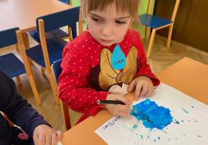 Zdjęcie przedstawia dzieci w trakcie rysowania